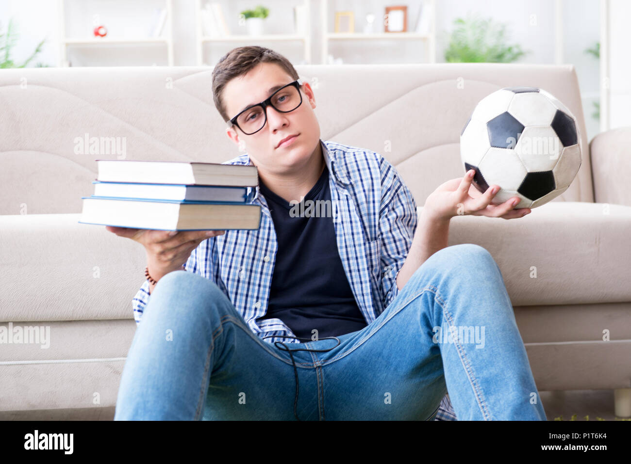 Giovane studente cercando di trovare il giusto equilibrio tra studiare e  giocare a calcio Foto stock - Alamy