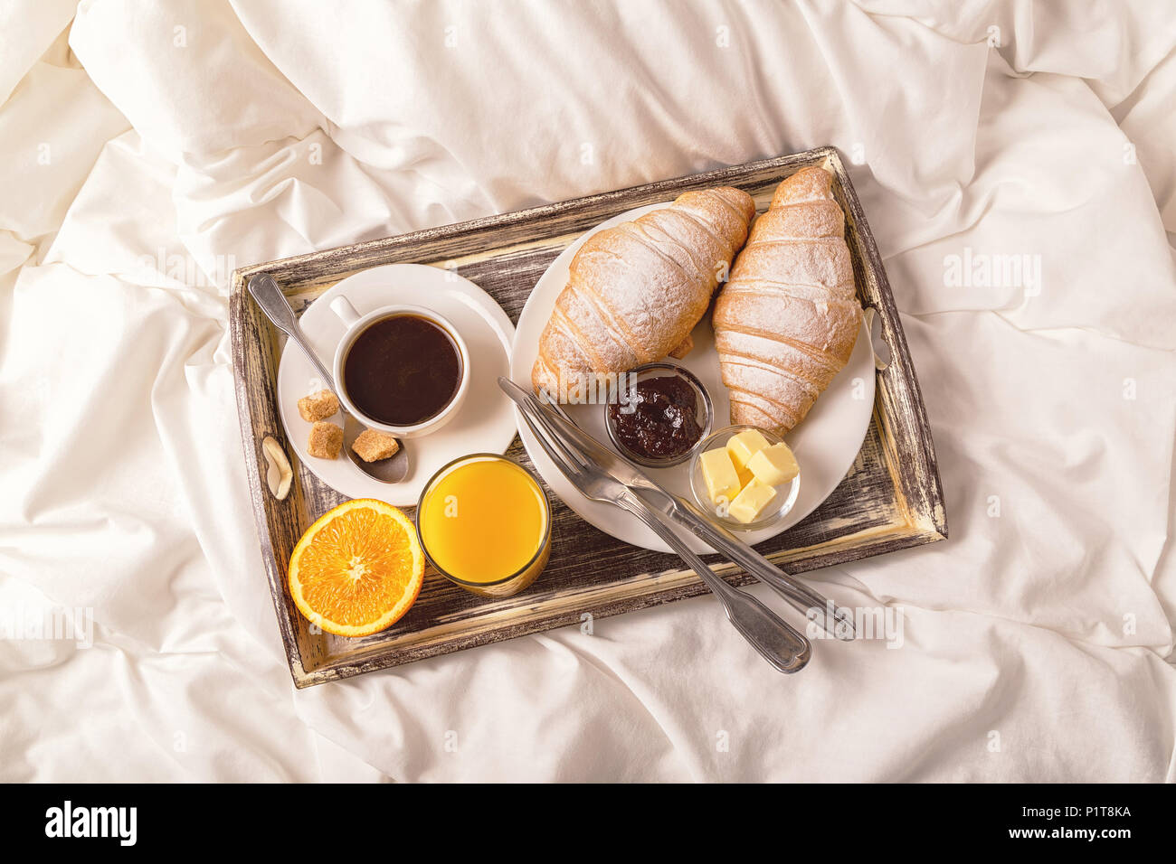 La deliziosa prima colazione a letto con caffè e croissant. Foto Stock