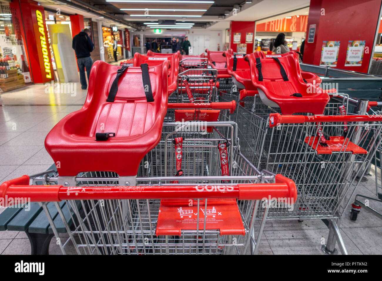 I carrelli della spesa di plastica con seggiolini per bambini al di fuori di un supermercato Coles. Melbourne VIC Australia. Foto Stock