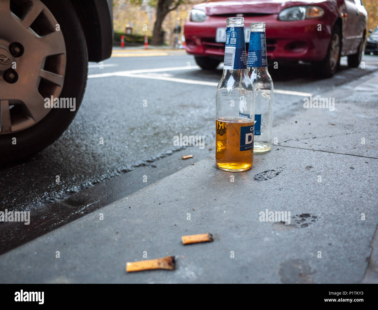 Bottiglie di birra e mozziconi di sigaretta abbandonati sulla strada nel CBD di Melbourne. VIC Australia. Foto Stock