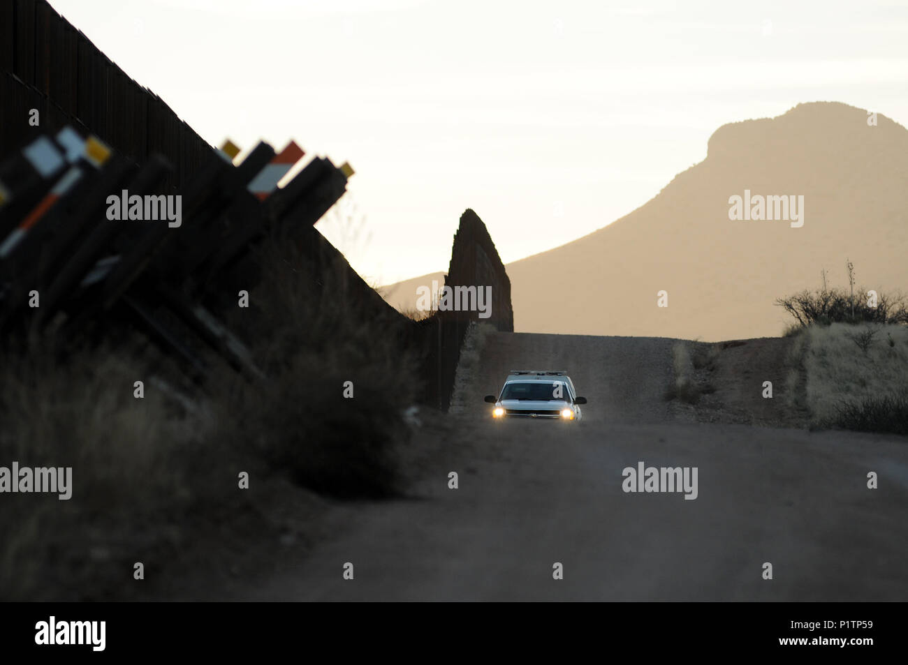 Un U.S. Pattuglia di Confine unità agente su una strada sterrata lungo gli Stati Uniti/Messico frontiera muro vicino al San Pedro River, Cochise County, Hereford, Arizona, Stati Uniti. Foto Stock