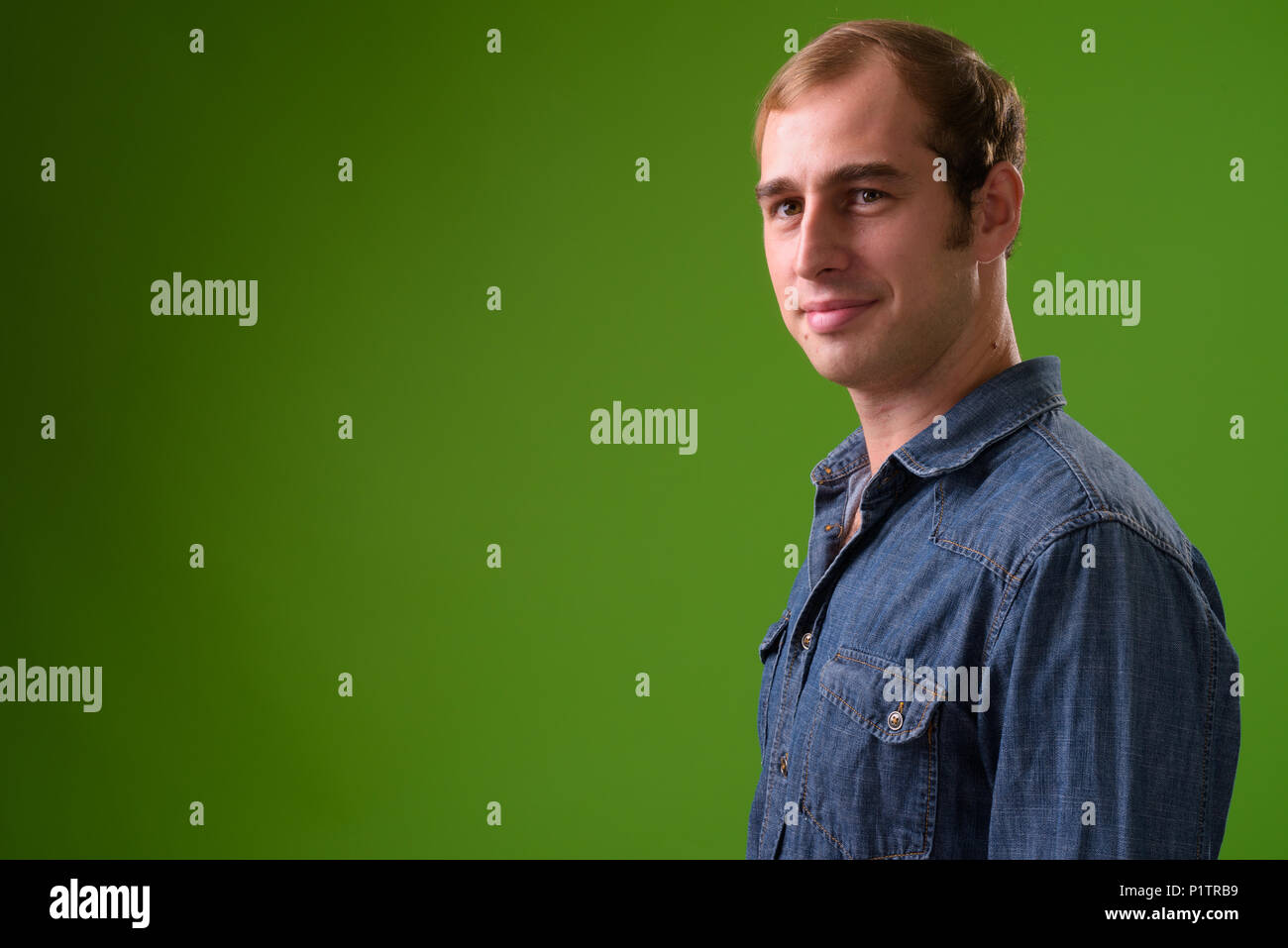 Giovane uomo contro lo sfondo di colore verde Foto Stock