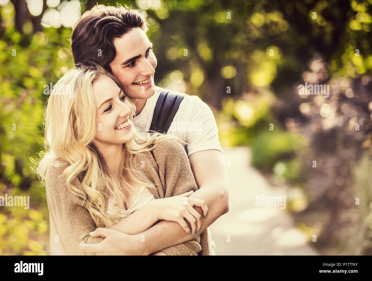 Una giovane coppia condivide un momento romantico insieme in un abbraccio mentre al di fuori del campus universitario; Edmonton, Alberta, Canada Foto Stock