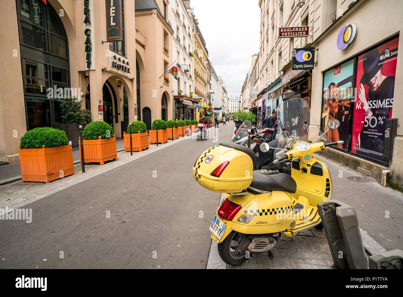 Un giallo brillante scooter parcheggiati sul lato di una strada di Parigi Foto Stock