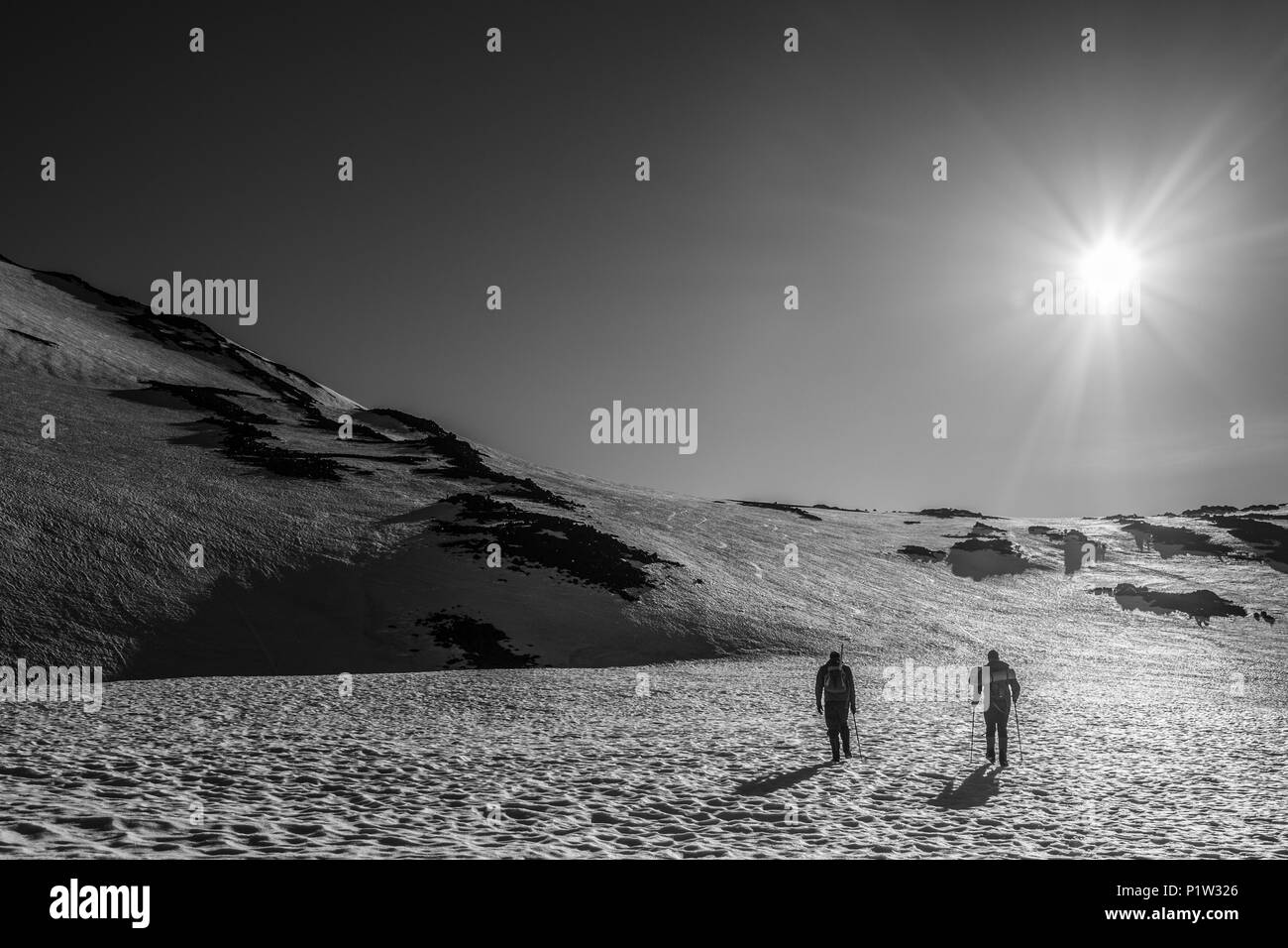 Due alpinisti attraversare tetro, alien distese di neve. In bianco e nero o seppia Foto Stock