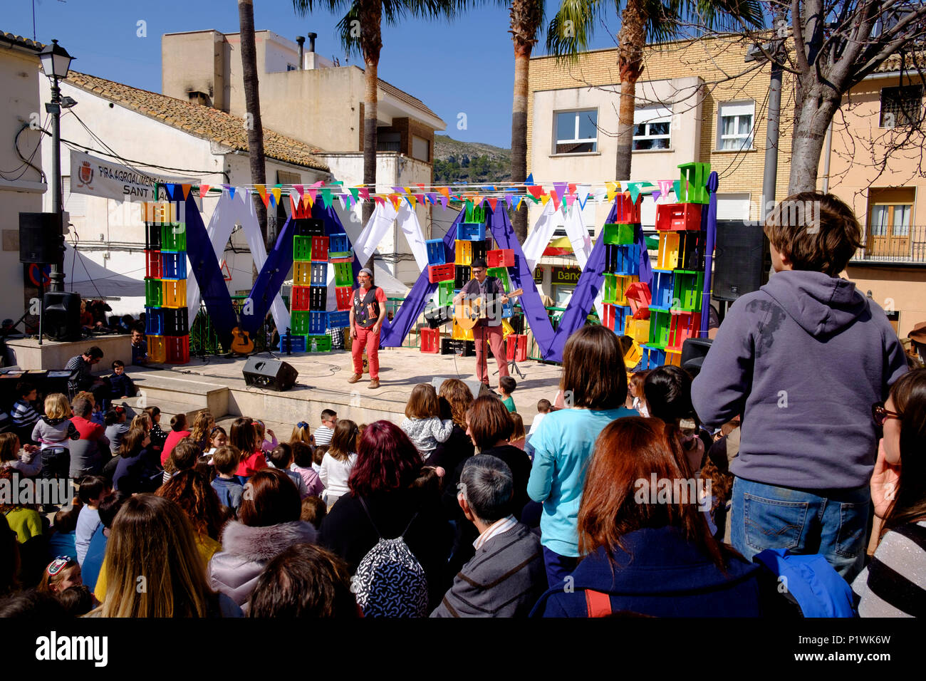 Due animatori commedia su un palcoscenico all'aperto guardato da una folla durante una Fiesta spagnola Foto Stock