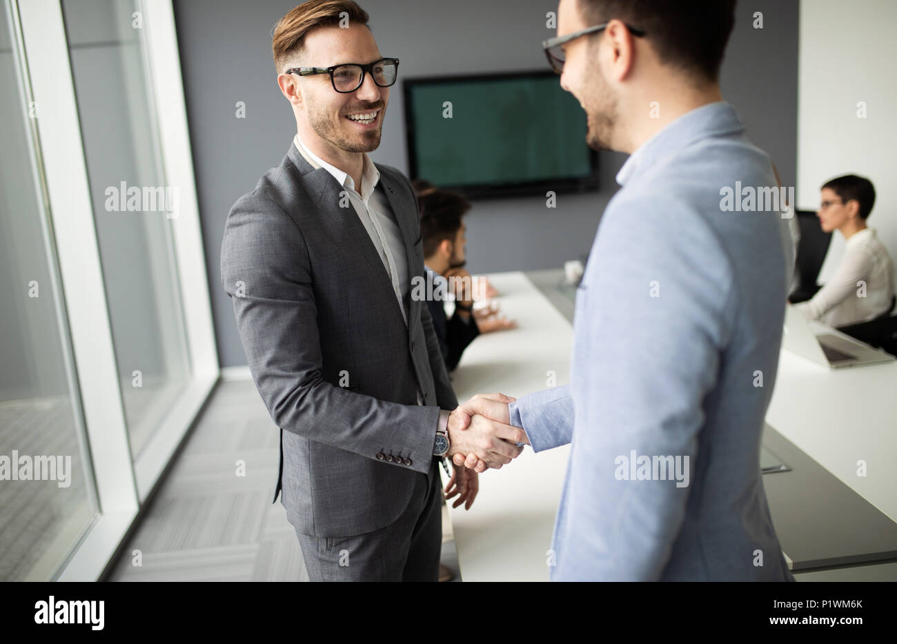 Due fiducioso uomo d affari si stringono la mano durante una riunione in ufficio Foto Stock