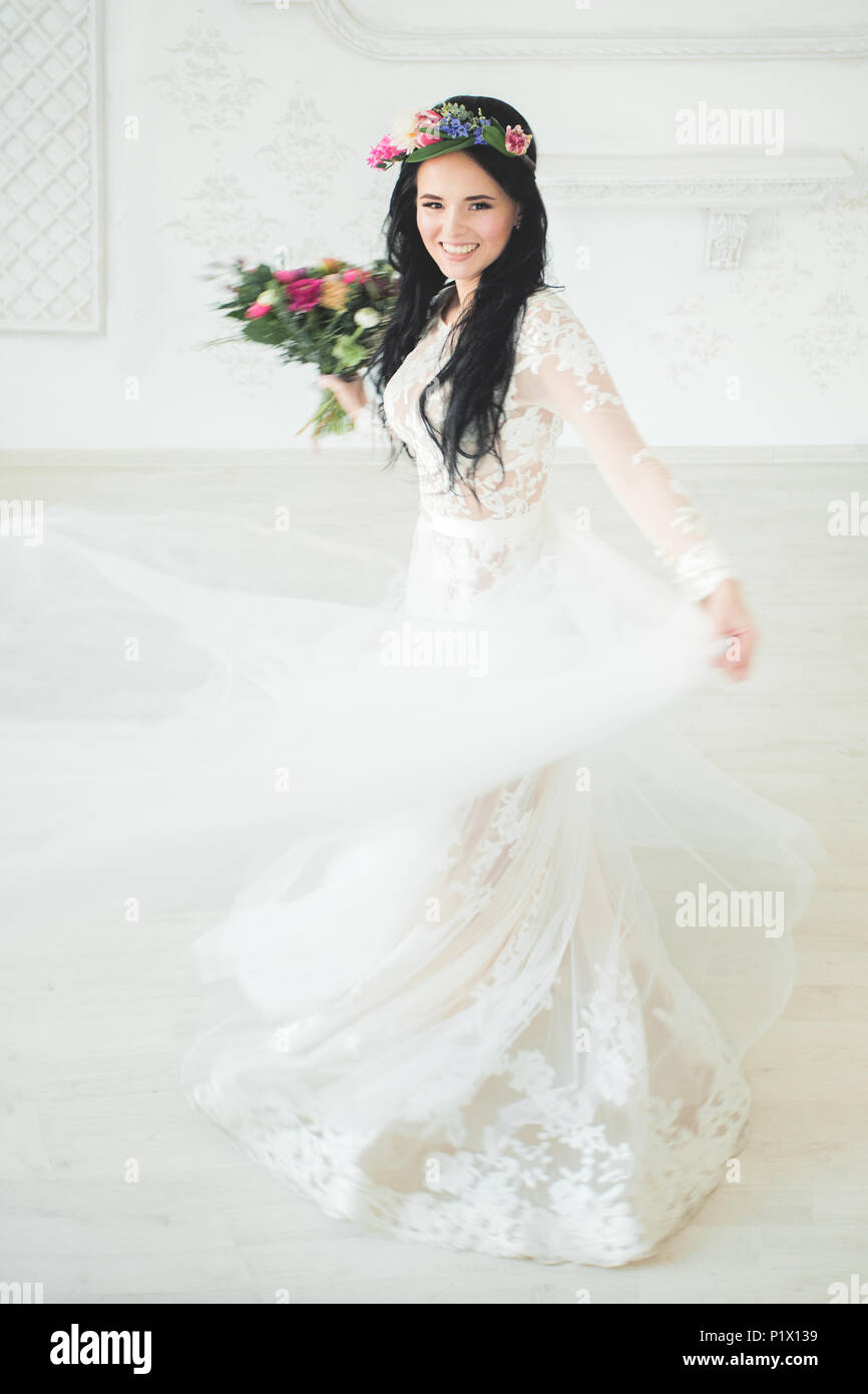 Bella giovane donna fidanzata in abito bianco. Sposa in movimento Foto Stock