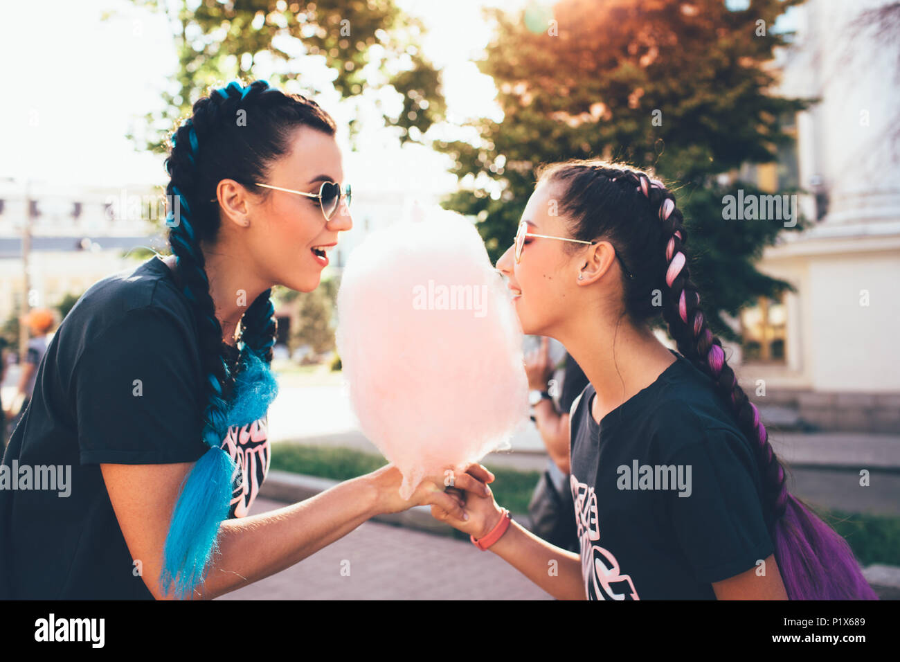 Sorridente madre e figlia di mangiare il cotone candy insieme , all'aperto Foto Stock