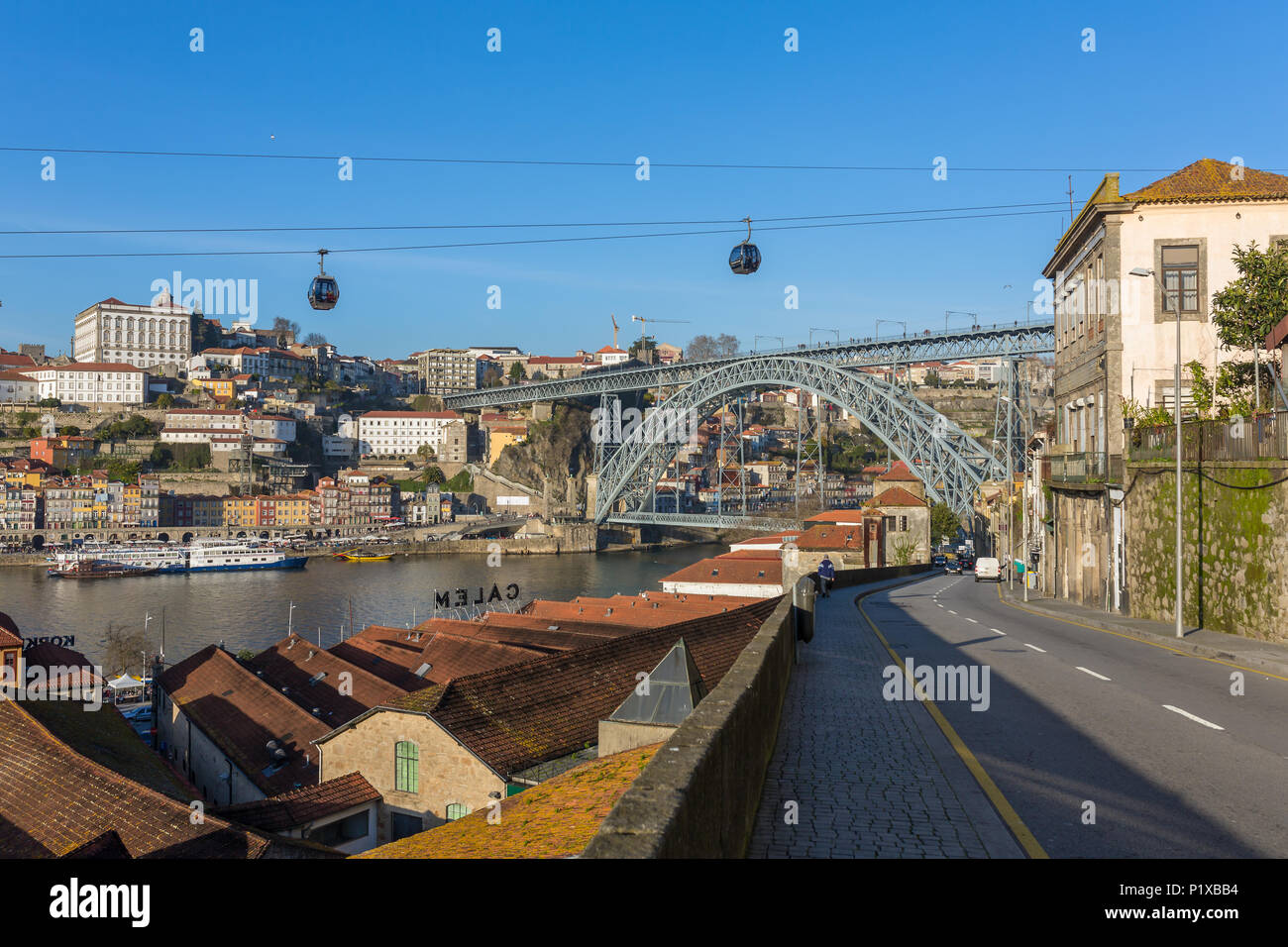 Vista della città storica di Porto con il famoso Ponte dom Luis, cavo auto e barche sul fiume Douro, Portogallo Foto Stock