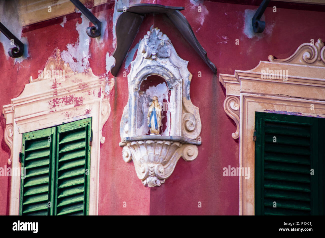 Tabernacolo con la statua della Vergine Maria posta sulla facciata di una casa all'angolo della strada Foto Stock