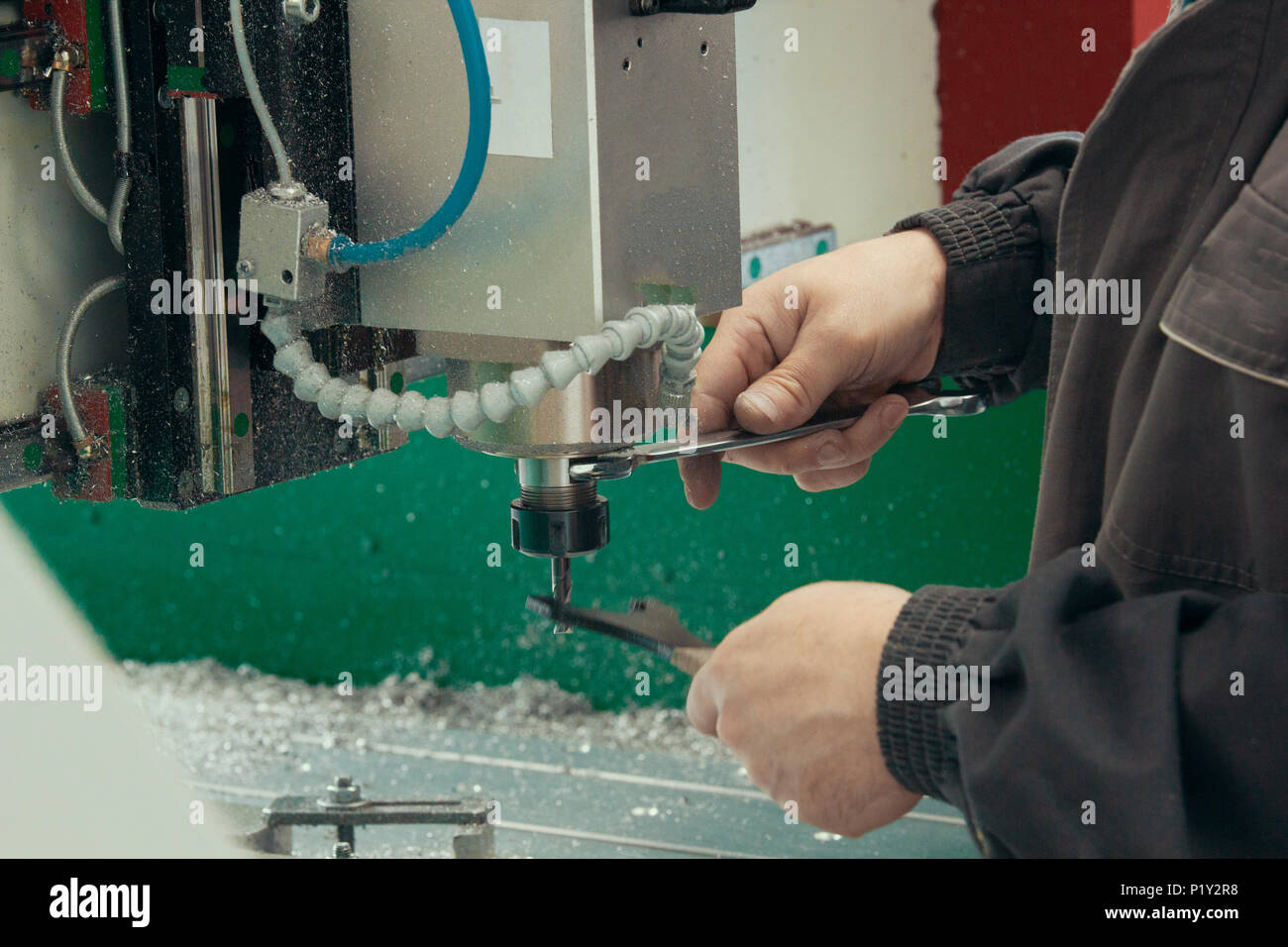 Lavoratore di sesso maschile mani lavorando con macchine CNC in fabbrica con torni Foto Stock