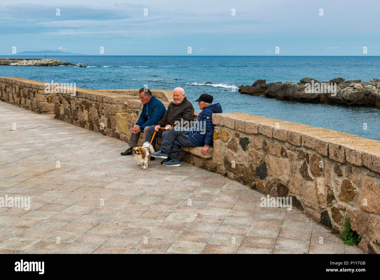 Castelsardo,Ital,11-Aprile-2018:Tre uomo seduto su una panchina e comunicare circa la vita di Castelsardo,castelsardo è famosa della skyline e il vecchio Foto Stock