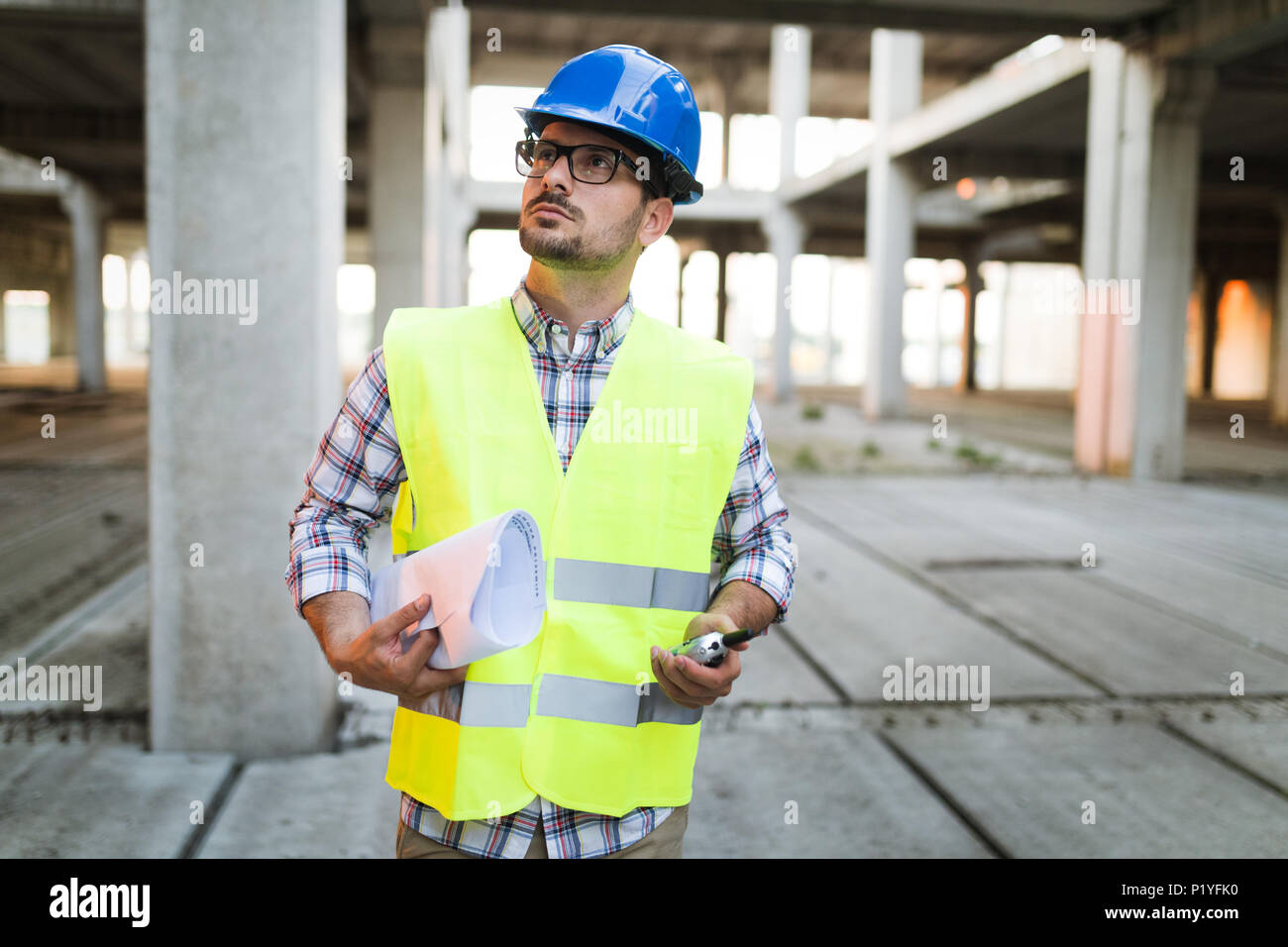 Immagine del sito in costruzione ingegnere guardando al plan Foto Stock