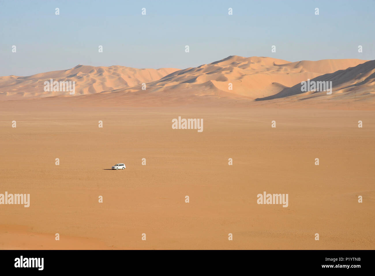 Il sultanato di Oman, Dhofar, Rub Al Khali desert, chiamato Empty Quarter, la più grande area di sabbia nel mondo,confine dello Yemen e Saoudi Arabia, un bianco 4 ruote è perso nel mezzo di un colore ocra di deserto di sabbia Foto Stock