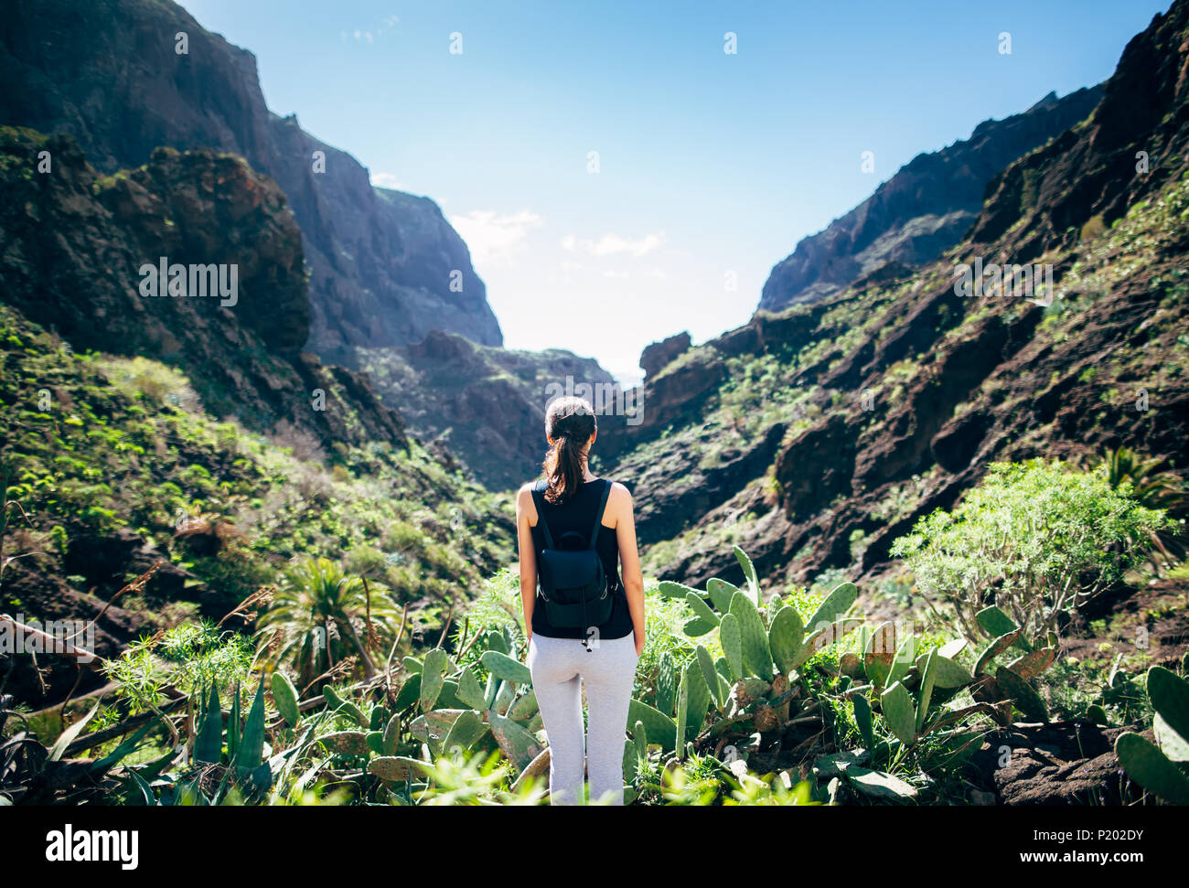 Giovane donna rilassarsi e godere scenico paesaggio di montagna nella valle Masca, Tenerife, Isole canarie, Spagna. Concetto di vacanza Foto Stock