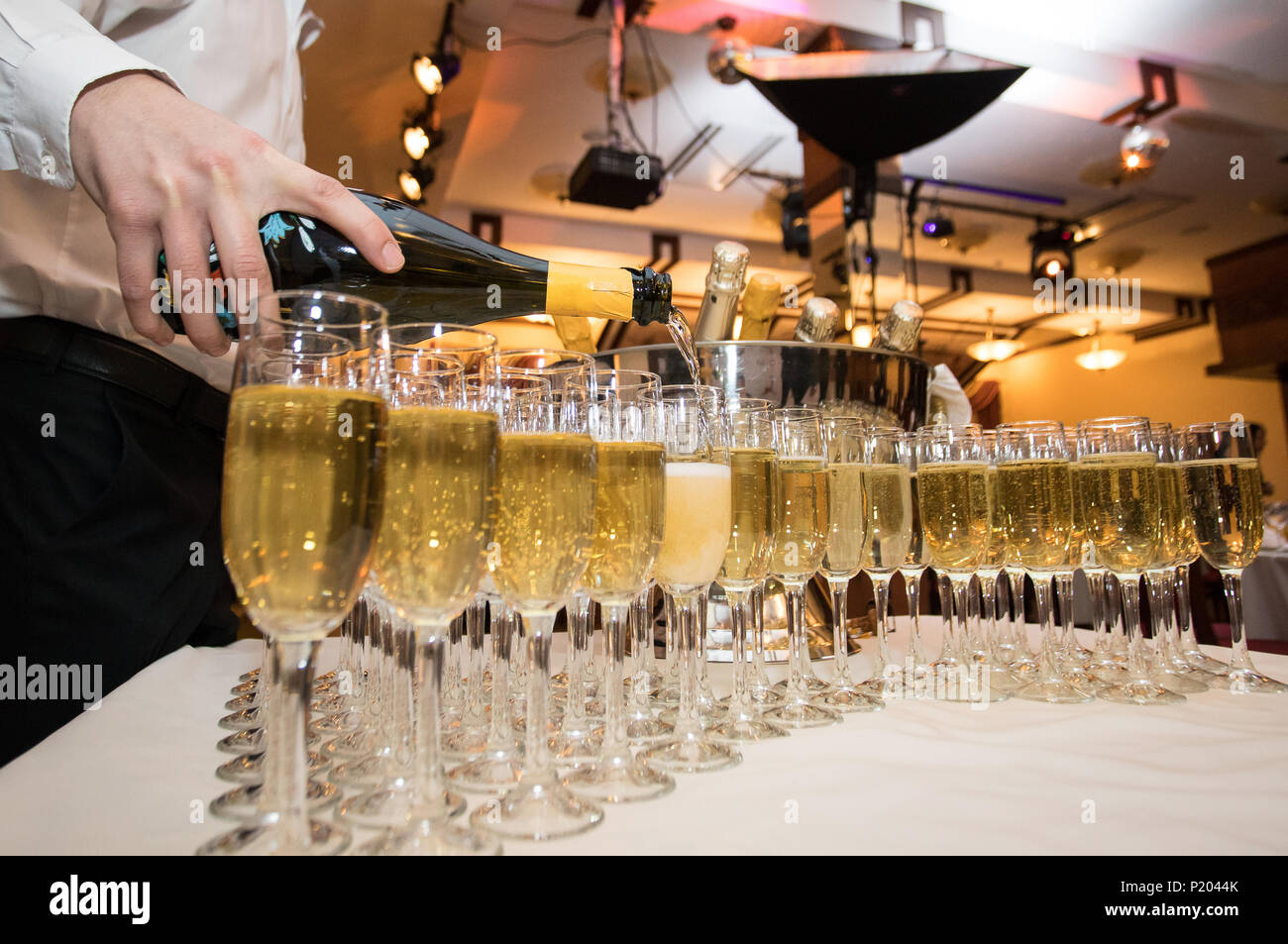Il cameriere versa lo champagne nei bicchieri a parte. Servizio di una vacanza Foto Stock