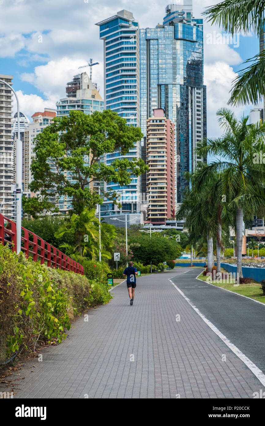 Esecuzione del pareggiatore in parco pubblico con city skylinebackground, Panama City Foto Stock