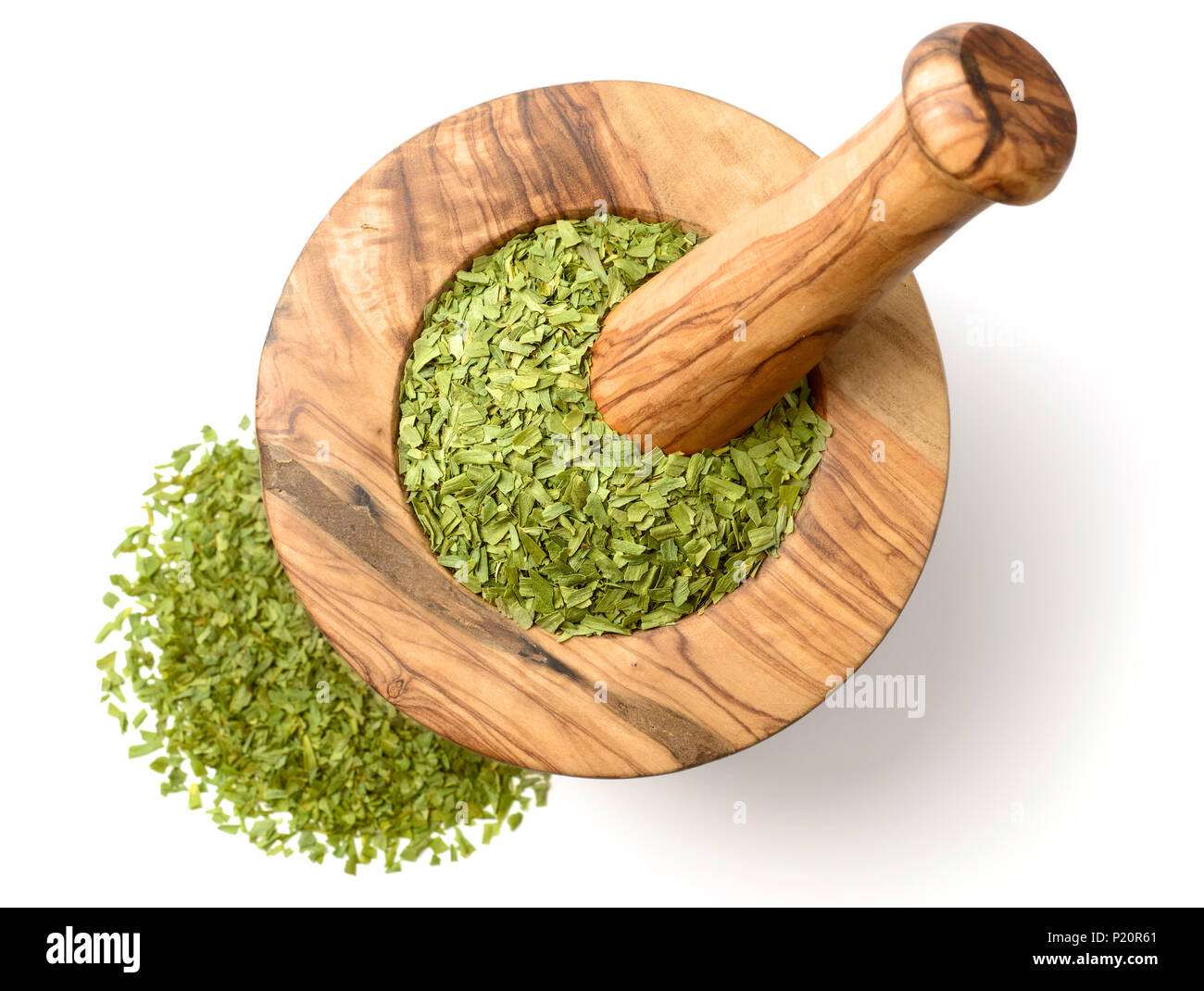 Essiccata foglie di dragoncello nel mortaio di legno, isolato su bianco Foto Stock