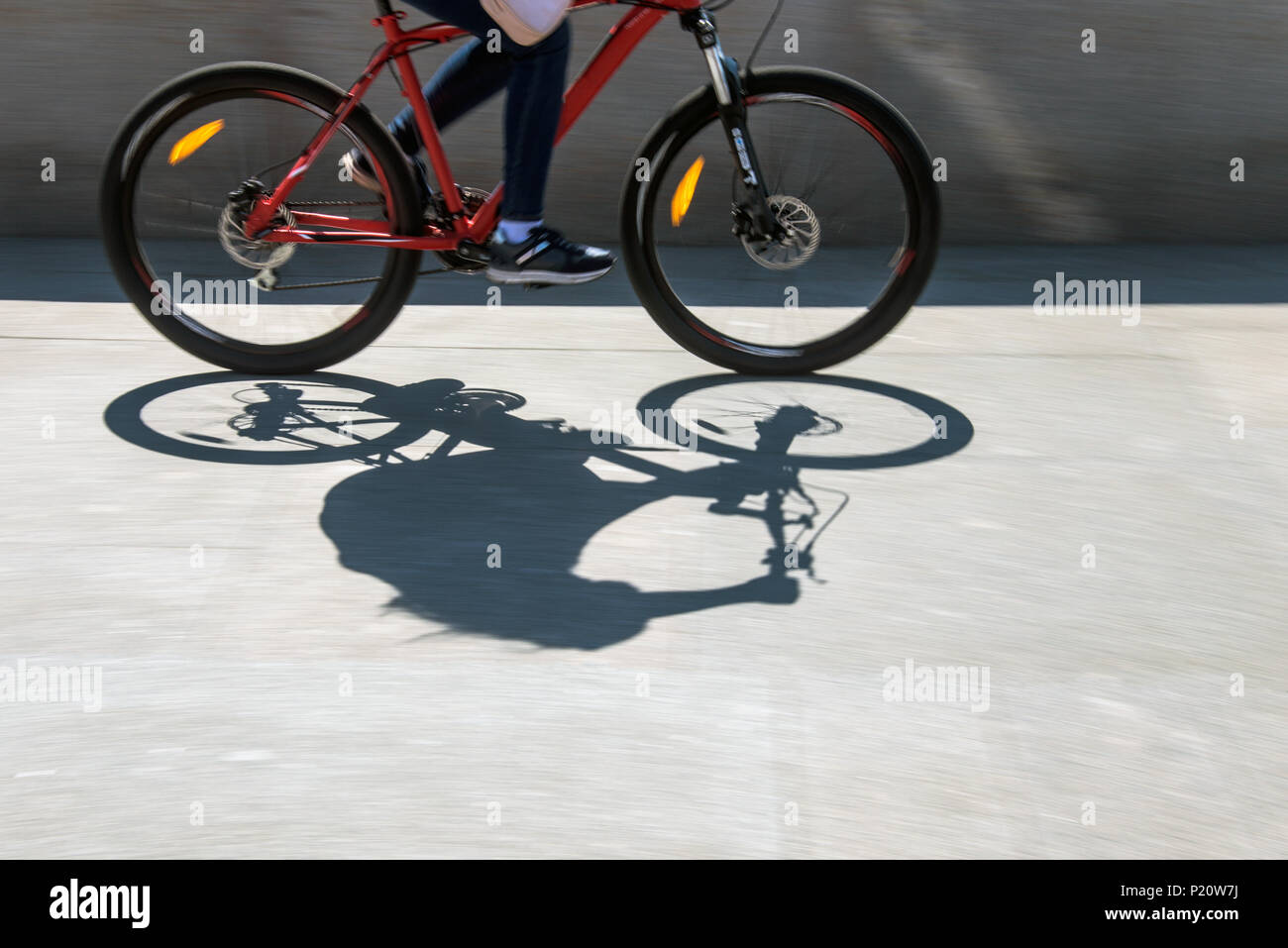 Sfocata ciclista silhouette e ombra su una bicicletta Foto Stock