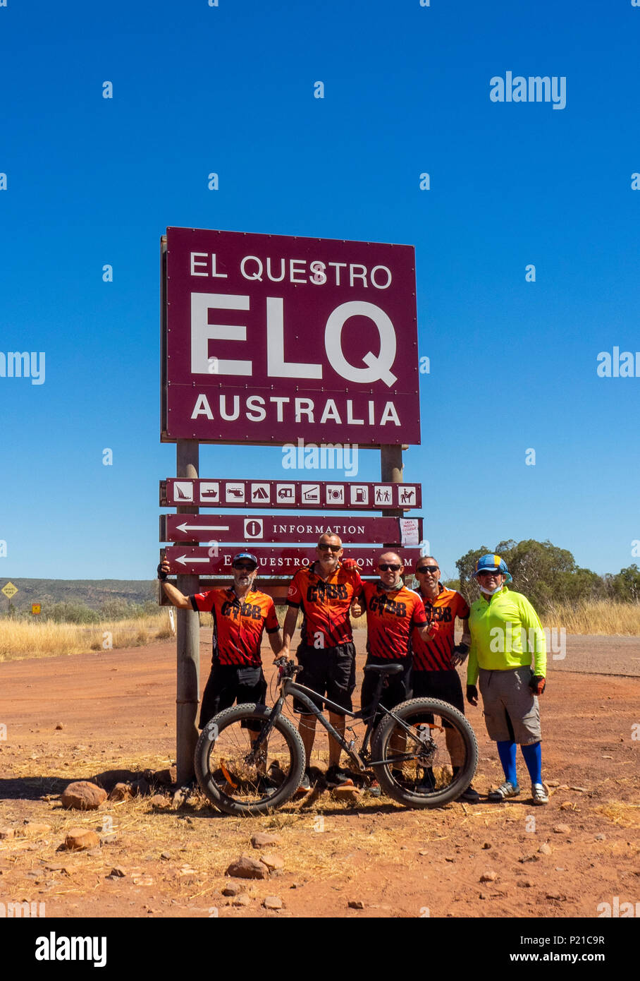 Gibb Challenge 2018 un team di ciclisti con un fatbike in piedi sotto la El Questro segno Gibb River Road Kimberley Australia Occidentale Foto Stock