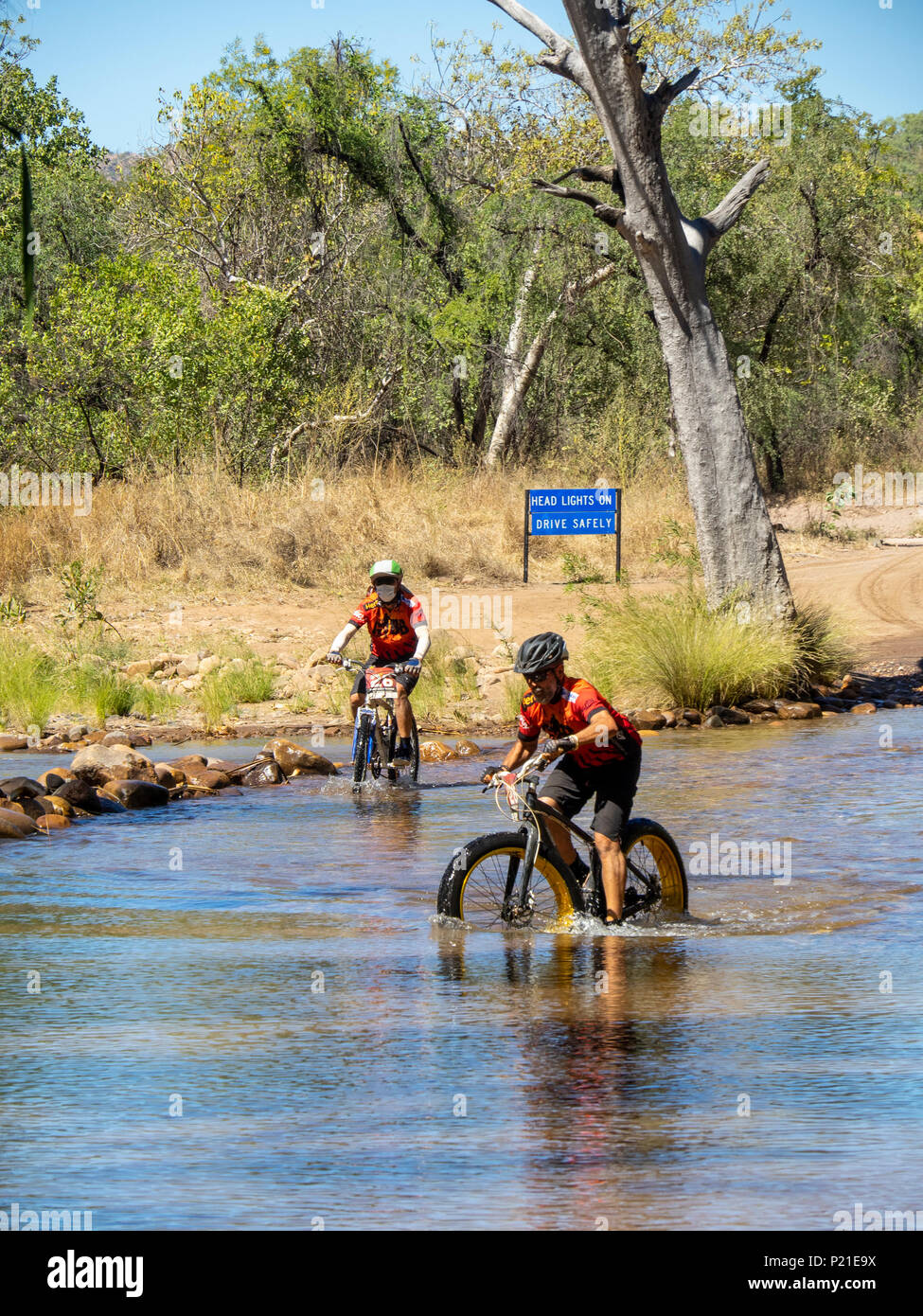 Gibb Challenge 2018 Due ciclisti su un fatbike e una mountain bike attraversando il fiume di Pentecoste a El Questro Station Kimberley Australia Foto Stock