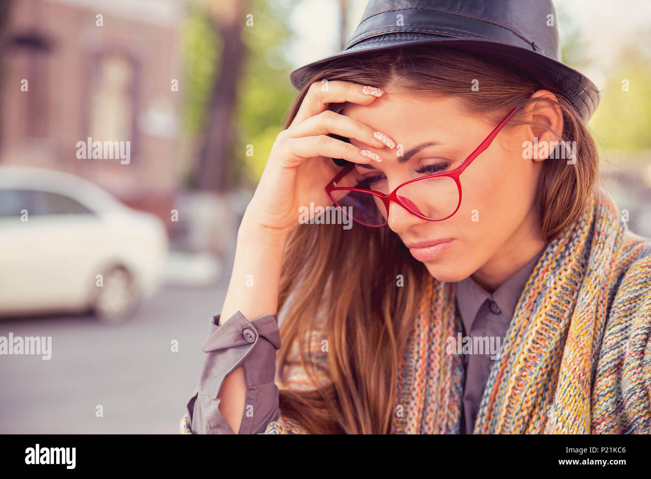 Sottolineato triste giovane donna seduta all'esterno. Città urban life style lo stress Foto Stock