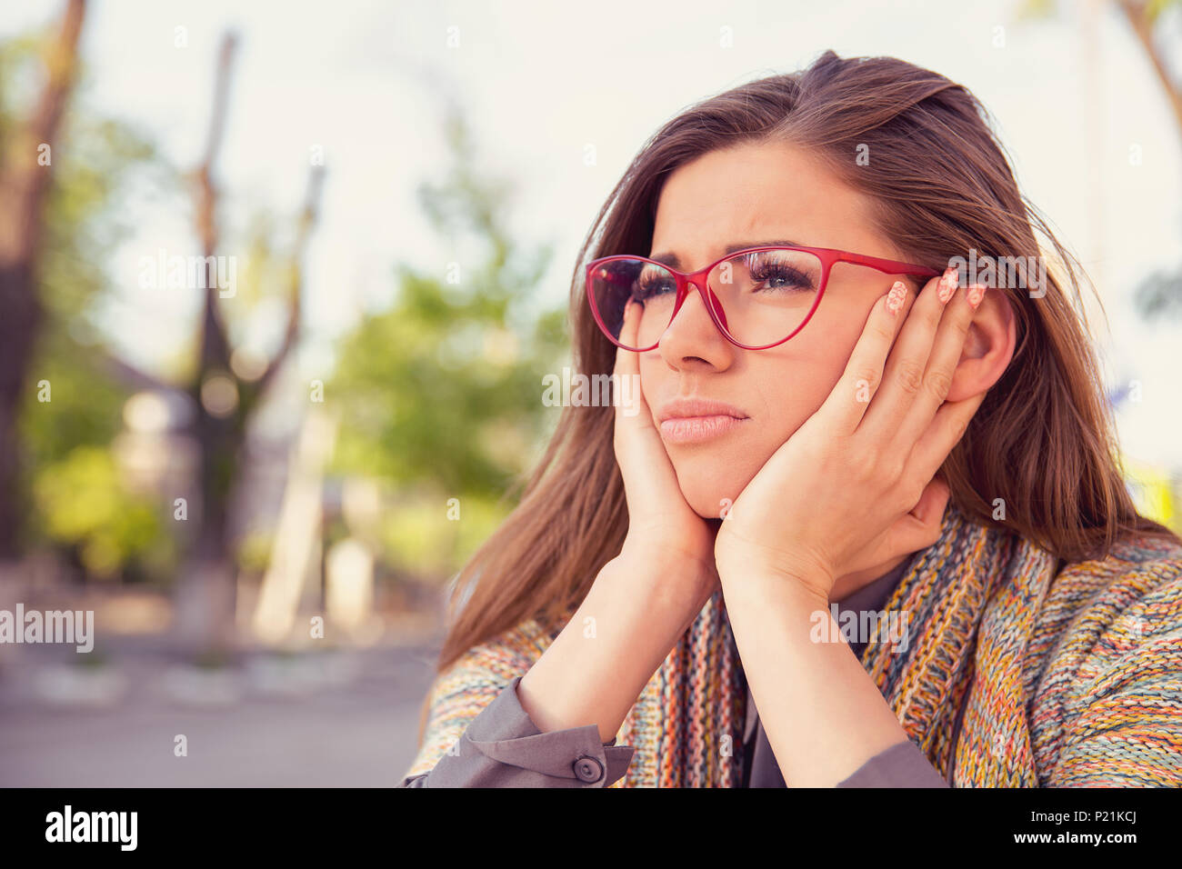 Premurosa donna triste guardando cupo seduti all'aperto Foto Stock