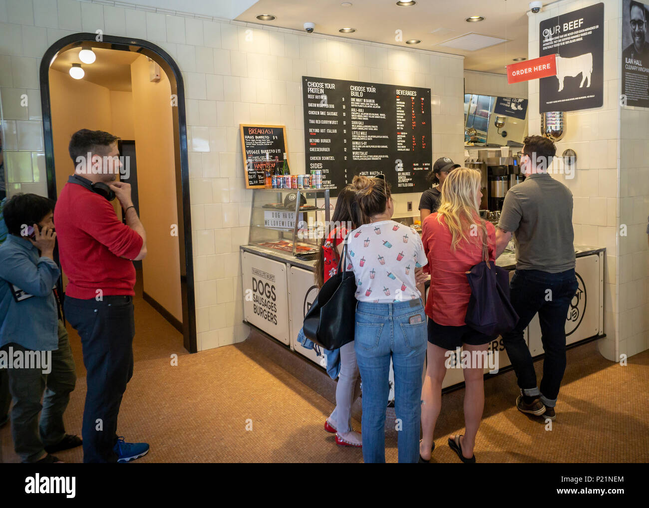 Ai clienti di effettuare gli ordini nel cane Haus il giorno di apertura del loro primo negozio a New York martedì, 12 giugno 2018. I visitatori sono stati trattati per un servizio gratuito di hot dog come un benvenuto alla loro posizione più recente di Soho. La catena è specializzata in fast pasti informali di hot dogs, salsicce, pollo e hamburger alla griglia su re rotoli Hawaiiano e guarnita con la loro firma 'Crea'. Cane Haus fu fondata nel 2010 a Pasadena, Caifornia con piani di aprire 300 nuovi franchising dal 2023. (Â© Richard B. Levine) Foto Stock