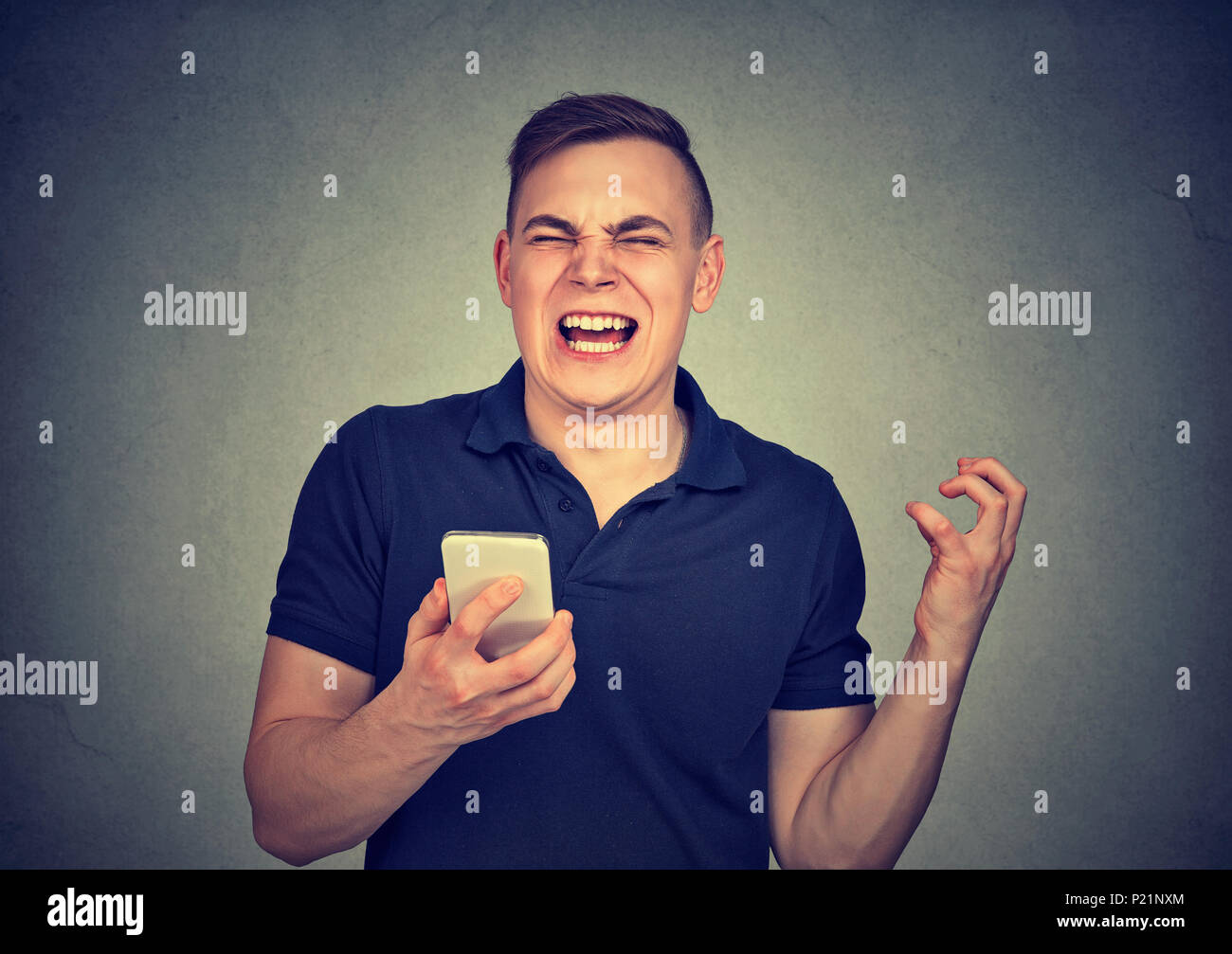L'uomo arrabbiato grida al suo telefono cellulare, furioso con il cattivo servizio scadente qualità di smartphone Foto Stock