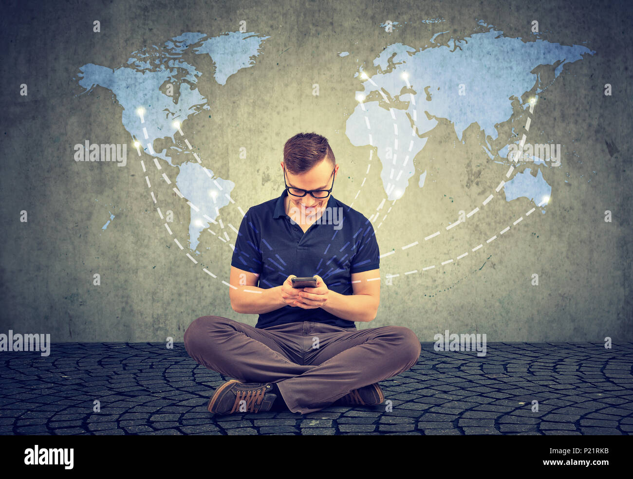 Casual Uomo seduto e utilizzo di smartphone e social media durante la comunicazione con le persone intorno al mondo. Foto Stock