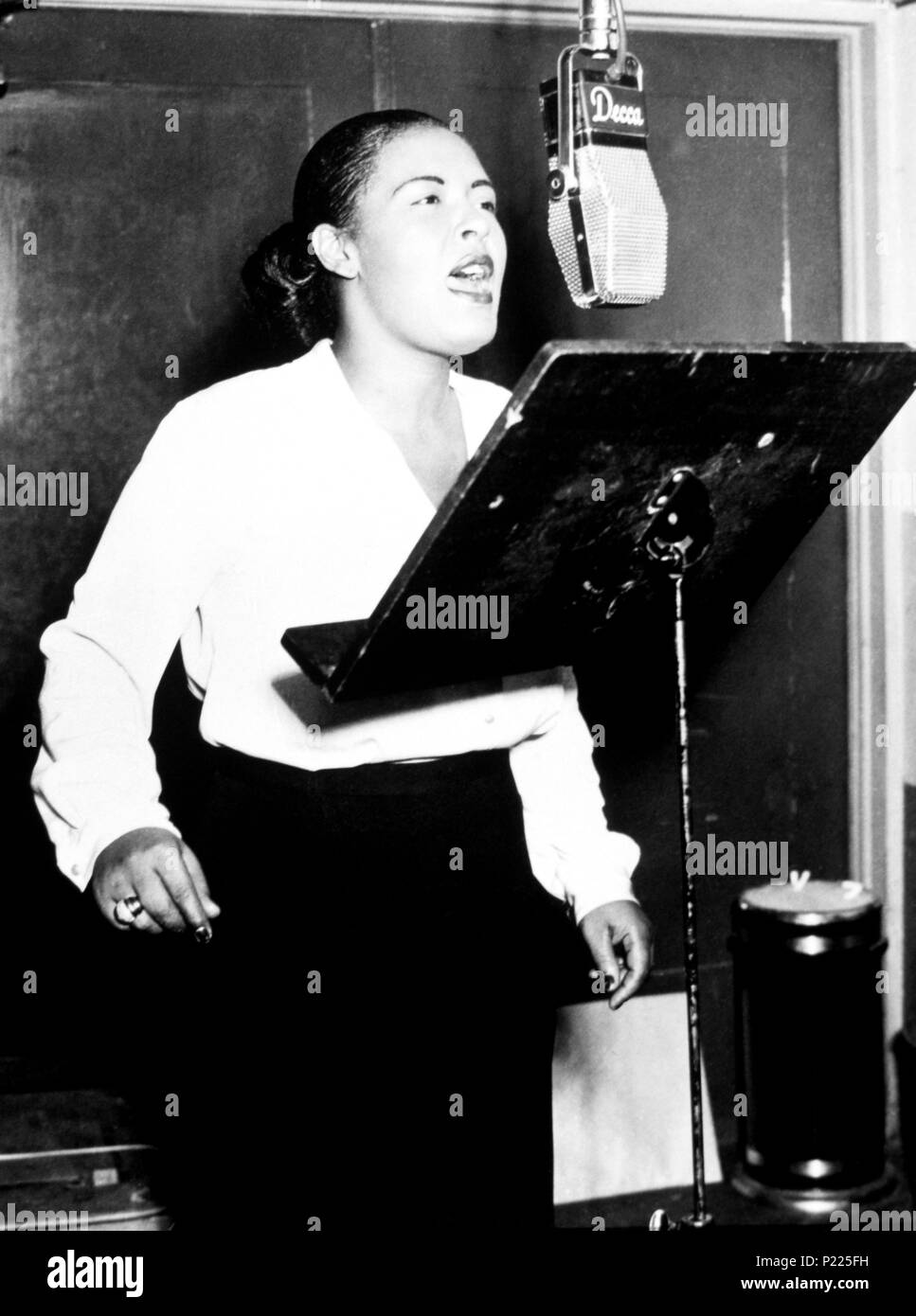 American jazz cantante Billie Holiday cantando in un microfono a un Decca sessione di registrazione 1946. Foto Stock