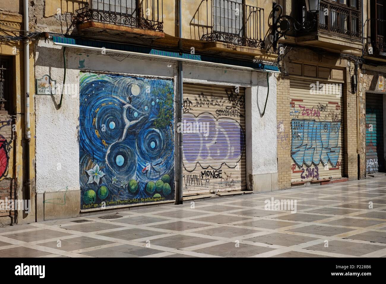Graffiti sul soleggiato shop fronti a Granada Spagna Foto Stock