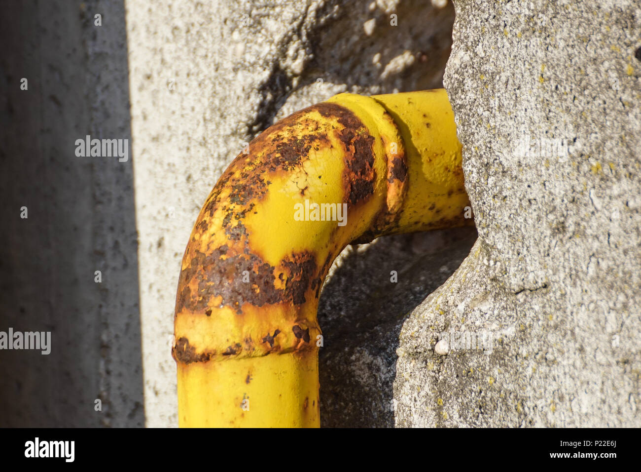 Esterno il gas naturale con alcuni giallo tubi in acciaio a parete grigia Foto Stock