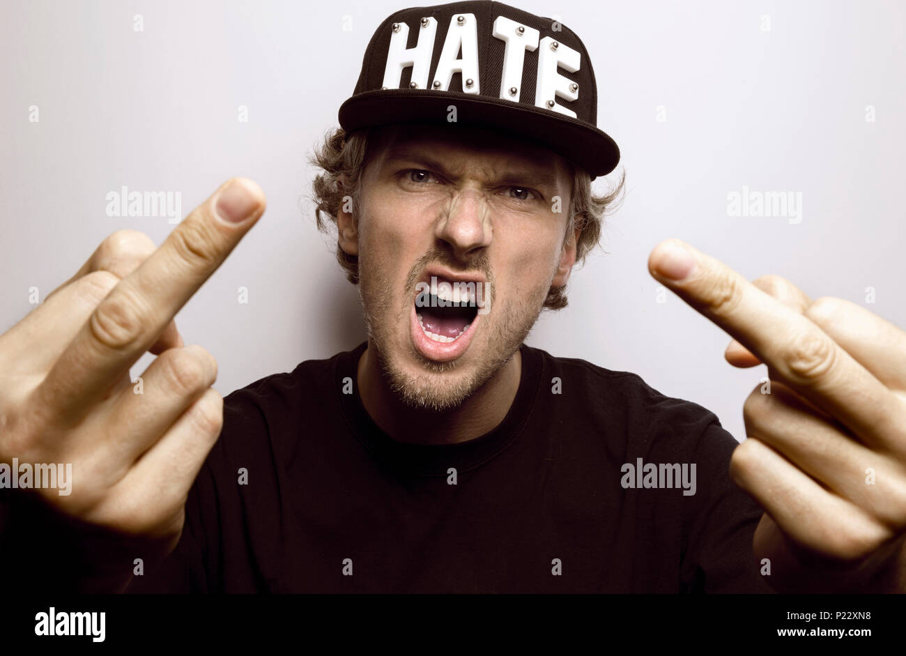 Arrabbiato hater urlando e mostrando la sua dita centrali Foto Stock