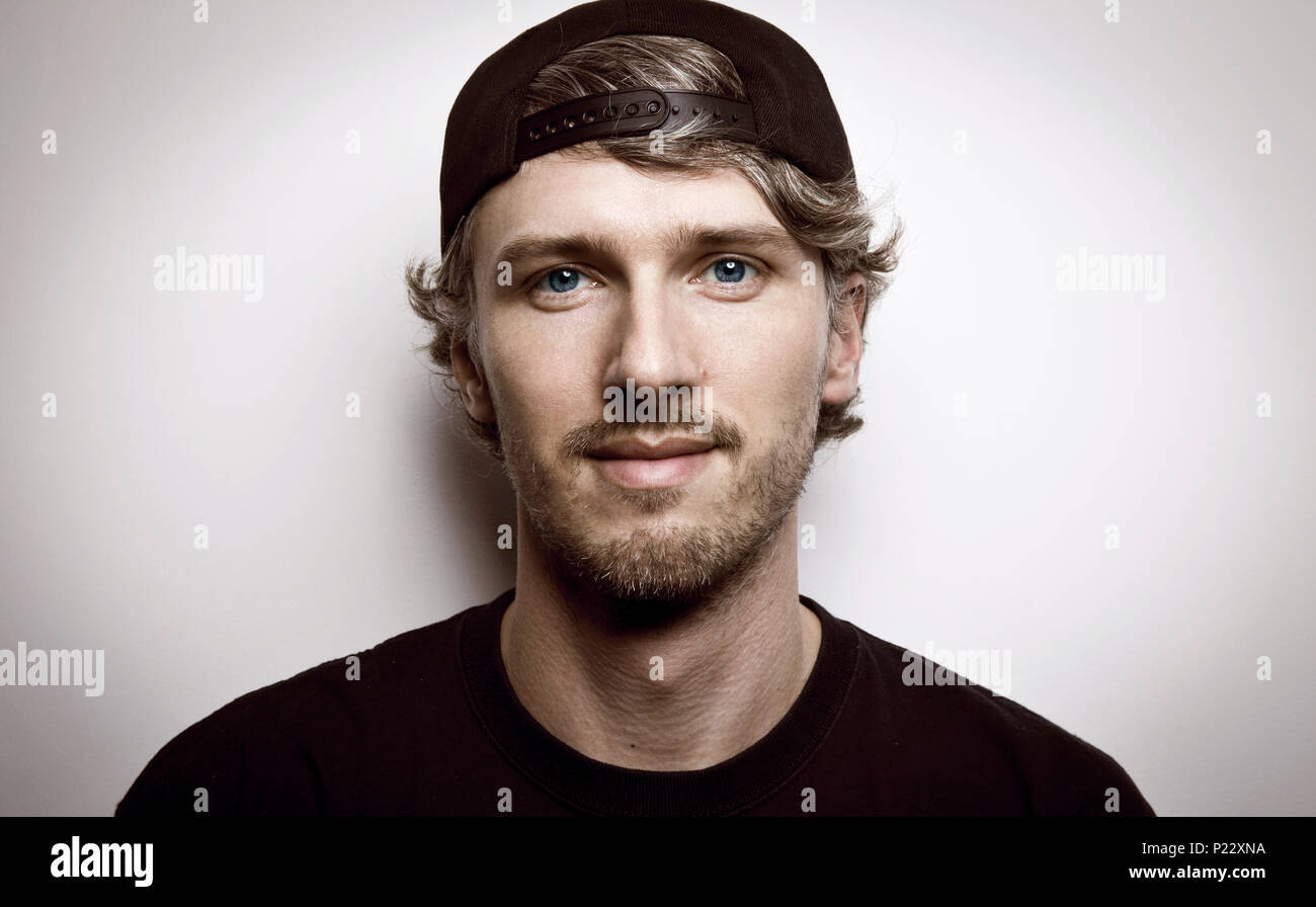 Giovane uomo con lunghi capelli ricci in un berretto da baseball Foto stock  - Alamy