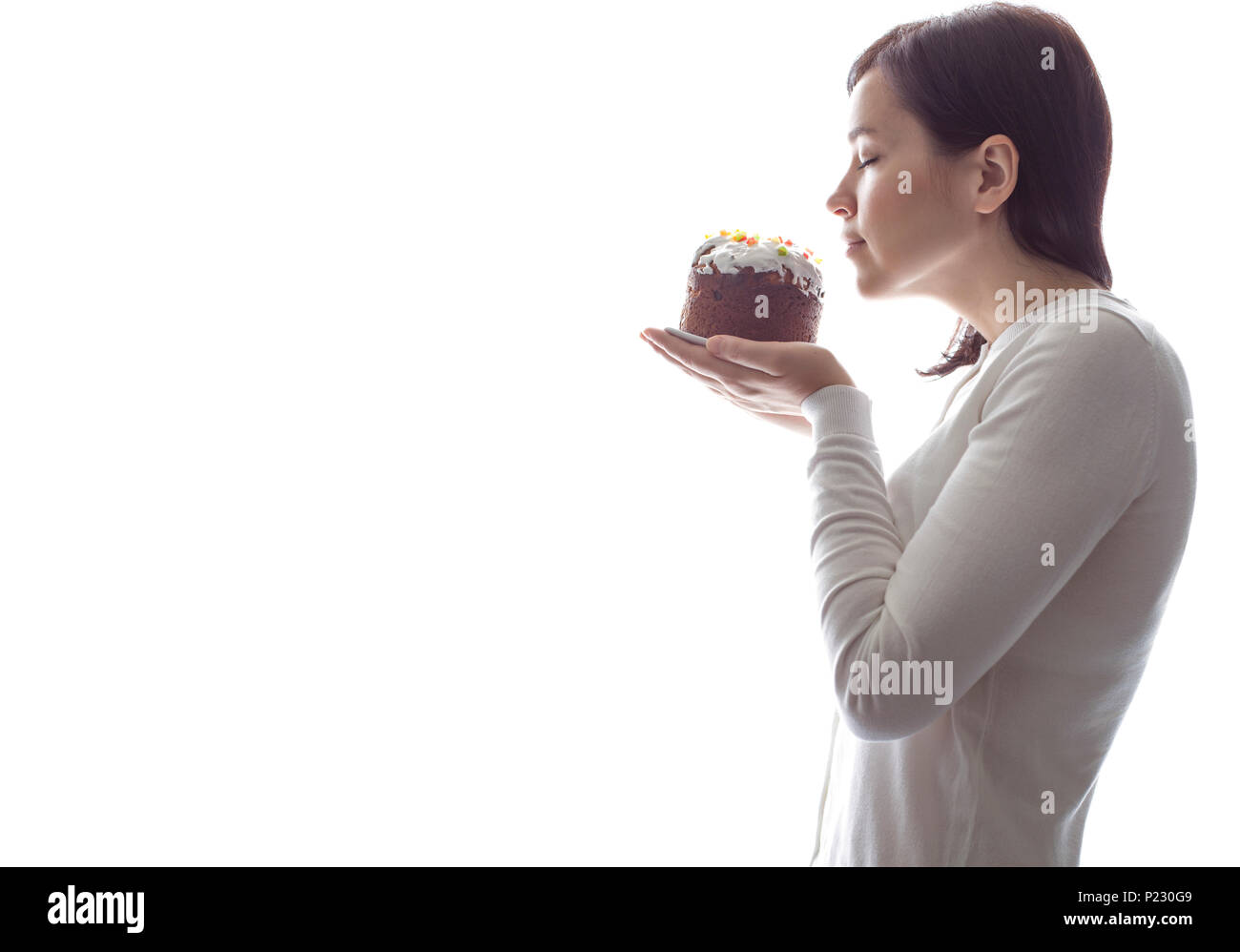 Giovane ragazza attraente lo sniffing una torta Foto Stock