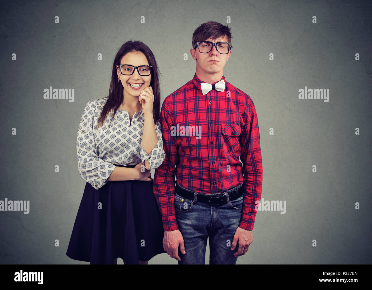 Ritratto di attraente donna affascinante dating con nerd in vecchio stile eyewear e un'usura eccentrica. Straordinario concetto di coppia Foto Stock