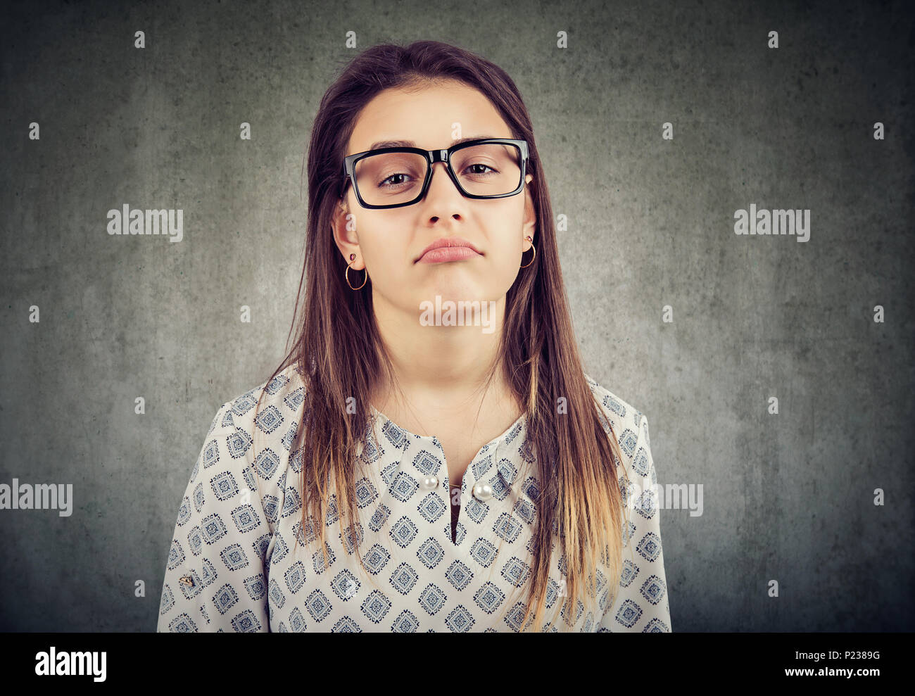 Annoiato infastidito giovane donna in bicchieri Foto Stock