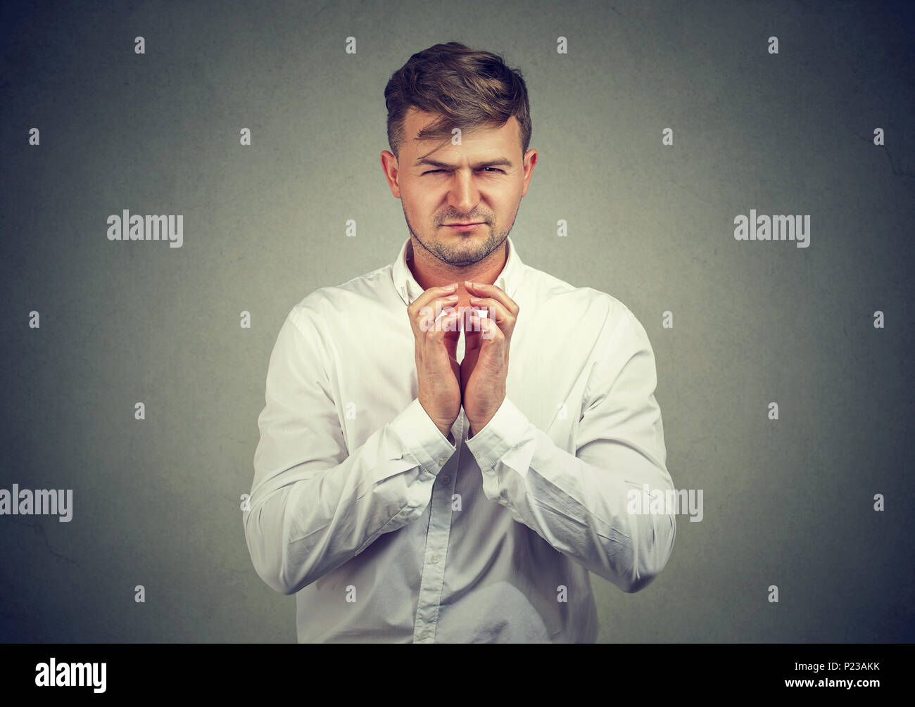 Barare uomo tenendo le mani insieme e che compongono il piano di vendetta cercando il male. Foto Stock