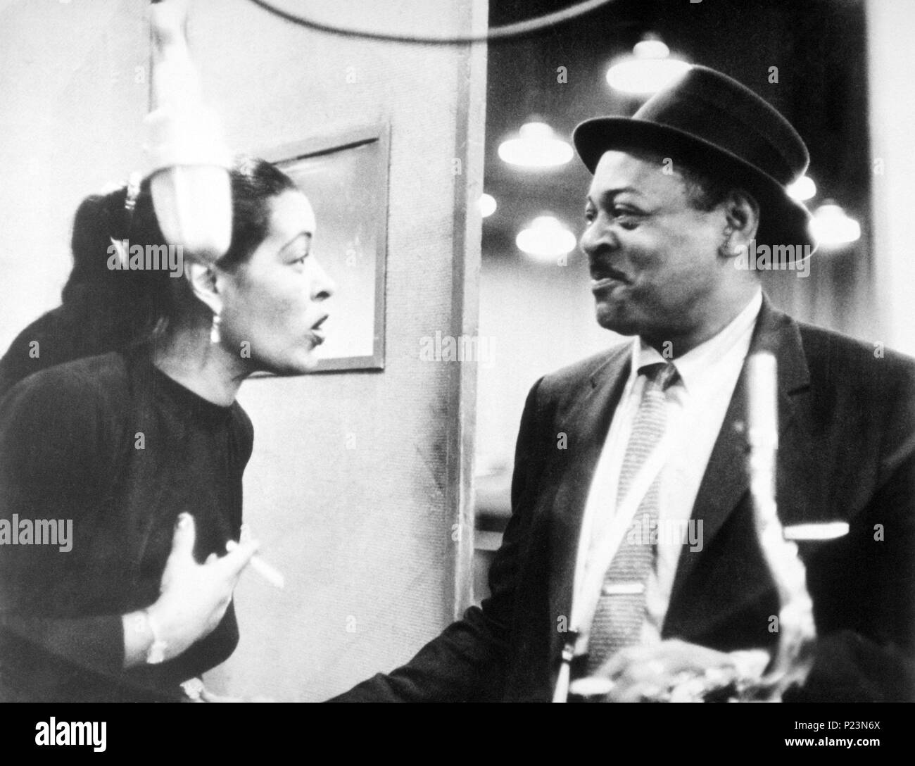 Vocalist americano Billie Holiday detiene una sigaretta come parla con il sassofonista Coleman Hawkins durante una sessione di registrazione per la Columbia Records. New Yourk, 1957. Foto Stock