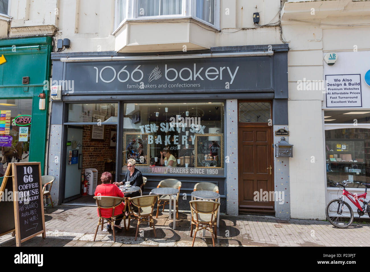 Paio di mangiare in un terrazzo esterno 1066 panificio, Hastings, East Sussex, Inghilterra, Regno Unito Foto Stock