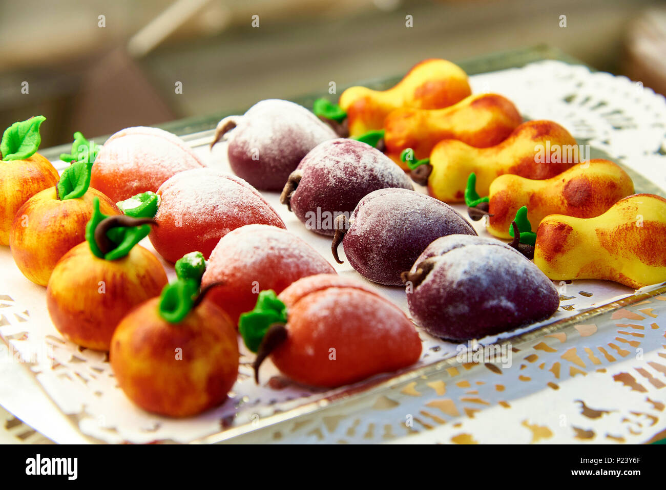 Candy realizzato in forma di frutta su un vassoio con un close-up di pizzo. Foto Stock