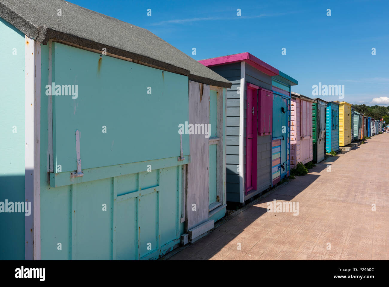 Una raccolta delle colorate dipinte beach capanne in shabby chic stile sul mare a st helends vicino a Bembridge Isle of Wight. vernice brillante. Foto Stock