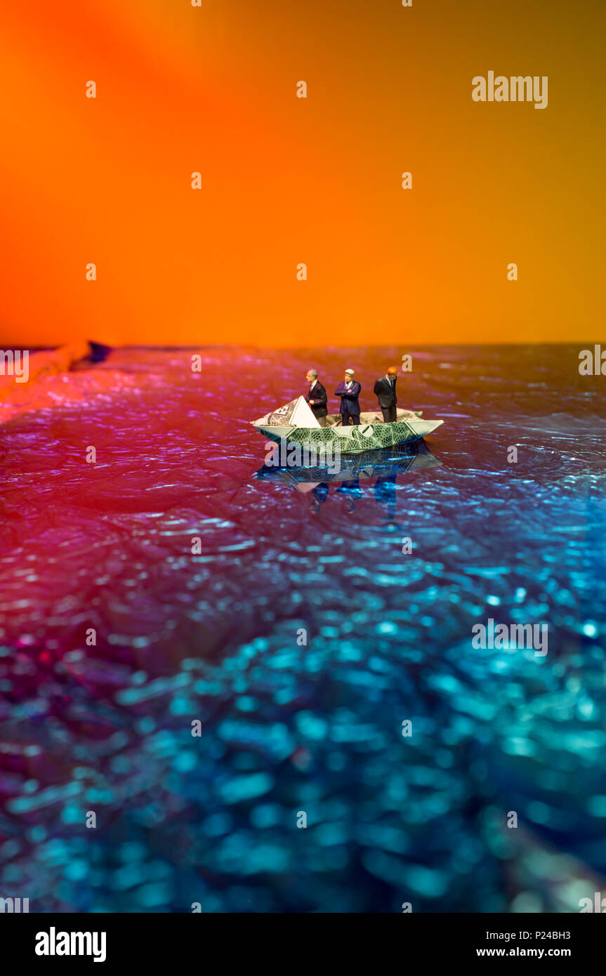 Miniatura imprenditori di figurine di giro sul dollaro origami yacht Foto Stock