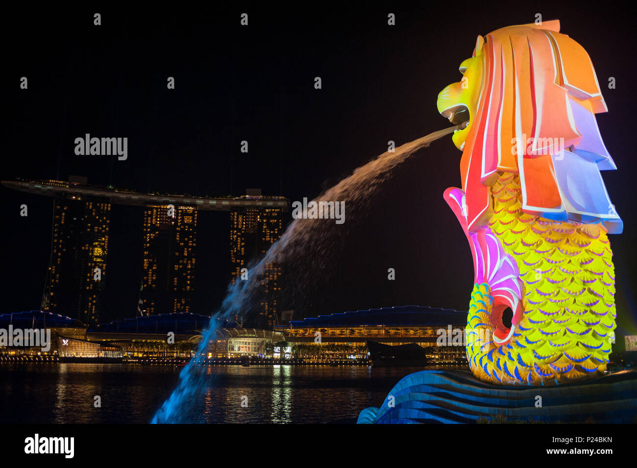 Singapore, Singapore, Merlion figura e Marina Bay sands hotel di notte Foto Stock