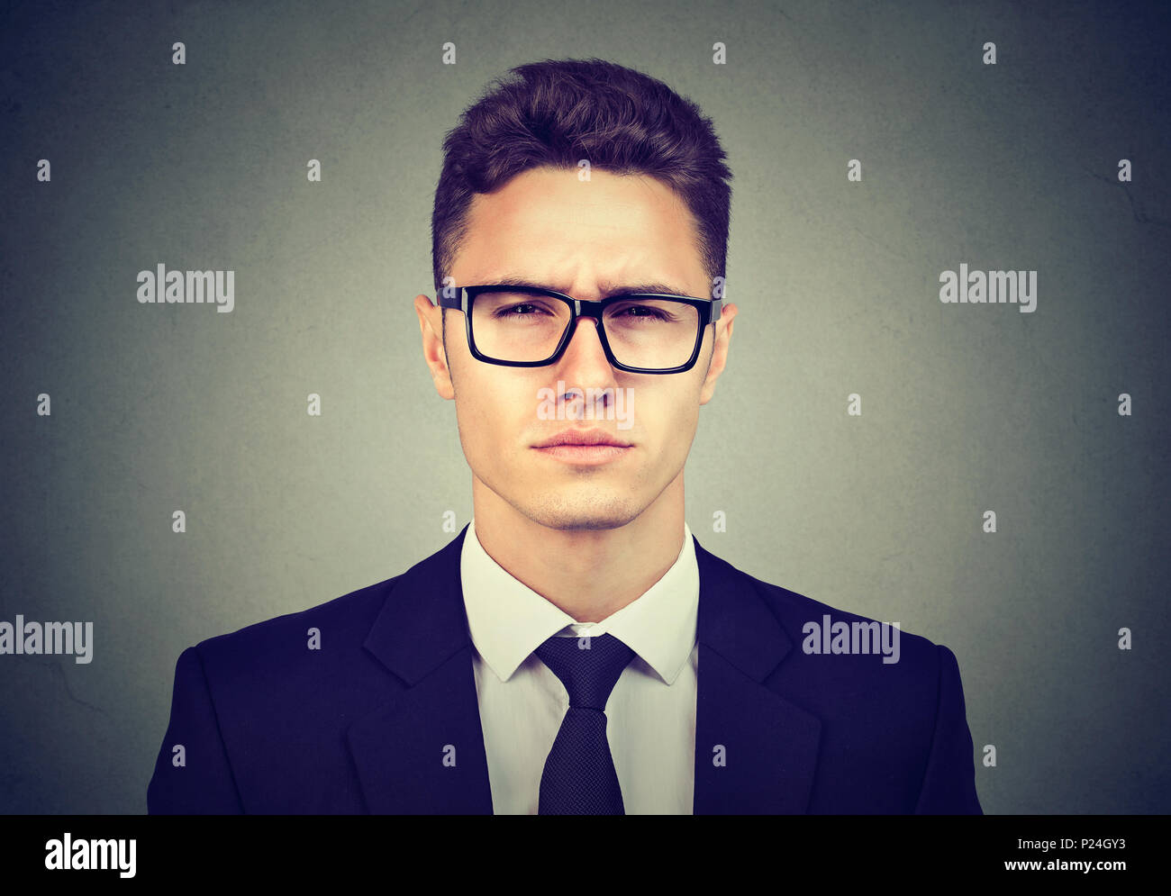Grave giovane uomo d affari in bicchieri Foto Stock