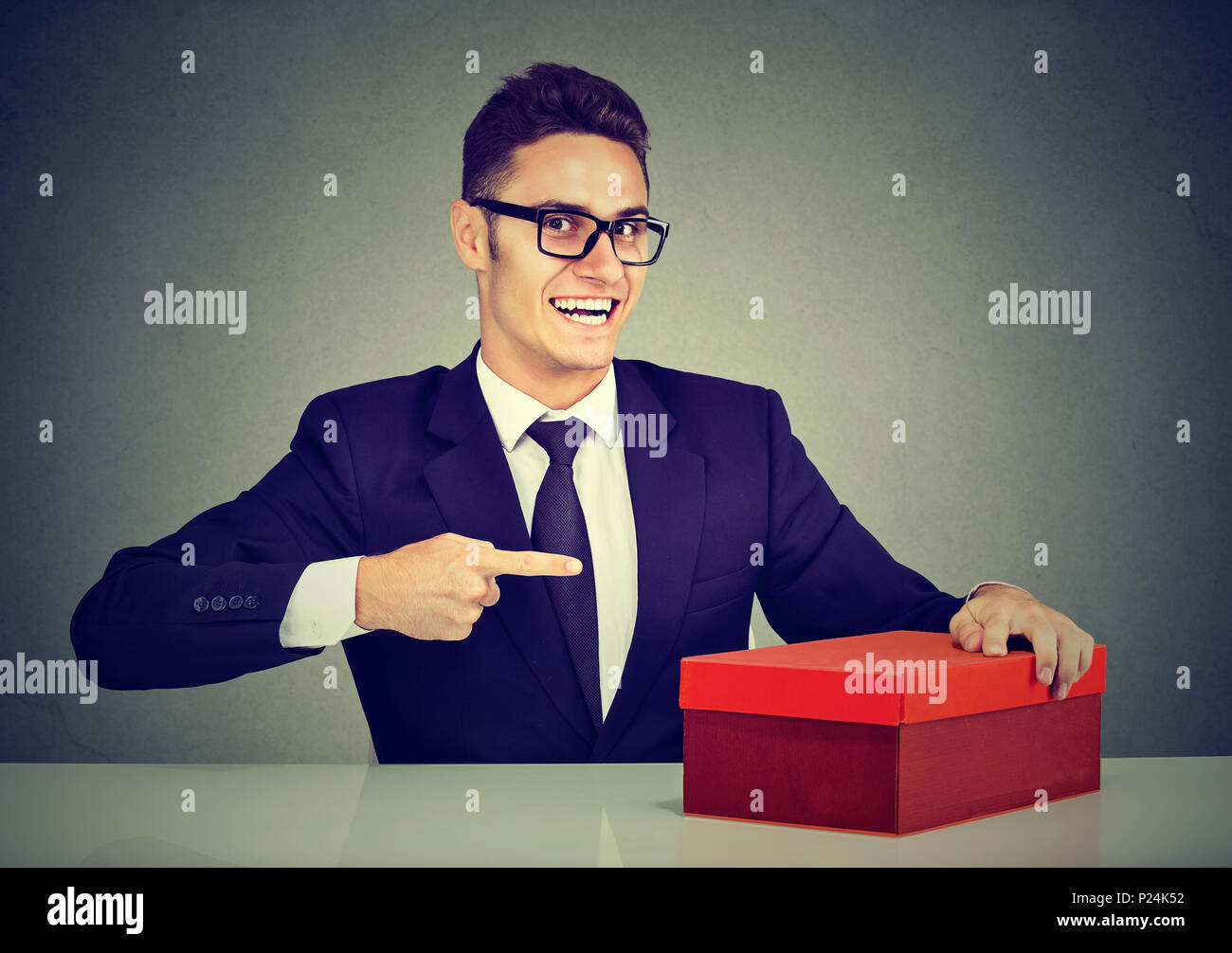 Sorridente venditore business man la pubblicità del suo prodotto in riquadro rosso Foto Stock