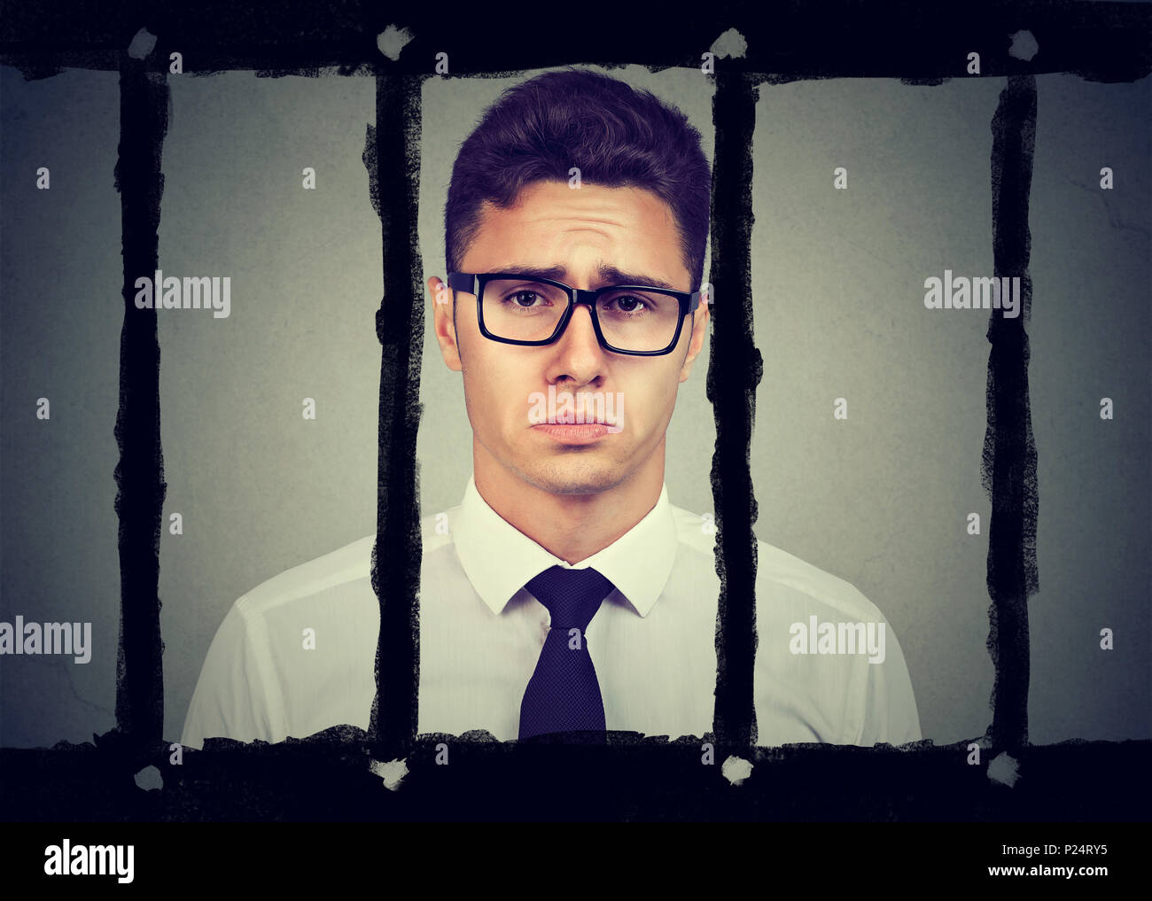 Triste giovane uomo d affari in carcere Foto Stock