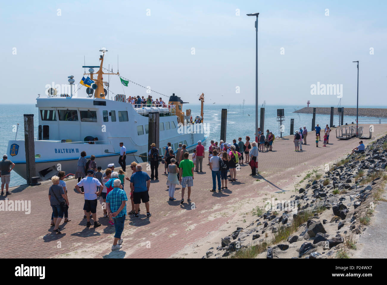 I turisti in attesa del traghetto per l'isola del Mare del Nord di Baltrum, Neßmersiel, Frisia orientale, Ostfriesland, Bassa Sassonia, Bassa Sassonia, Germania Foto Stock